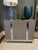 Three-drawer custom-built chests. Solid oak construction, grey finish, shiny metal detail along facing and base. Excellent...
