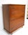 A very well crafted five drawer wood dresser with sculptural curved polished metal pulls having plenty of storage with the...