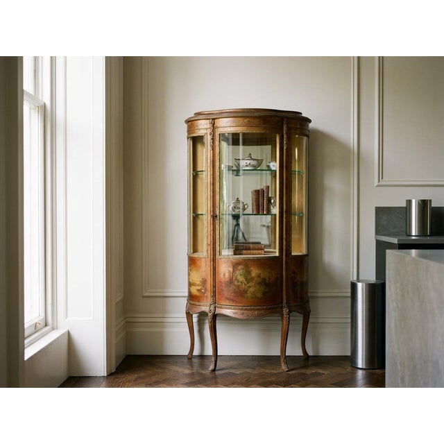 A 19th century French Louis XIV style Vernis Martin vitrine with hand painted panels, cast bronze mounts and curved glass....