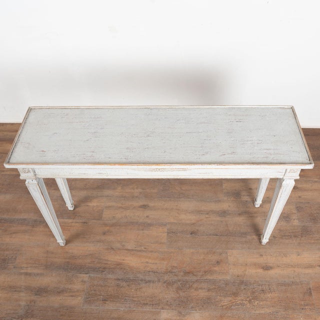 Early 20th century Swedish Gustavian style console table, crafted in pine. The table stands on tapered fluted legs topped...