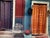 Colorful signed and dated 1983 artwork depicting two vividly painted doorways with patterned curtains, a chair, buckets...