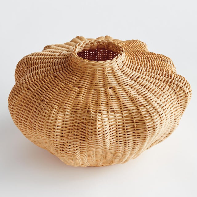 This palm rattan woven vase features an undulating shape wrapped around a rigid wire frame. It takes a masterful weaver to...
