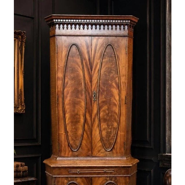 An outstanding antique Edwardian corner cabinet, dating to the early 20th century and beautifully crafted in richly...