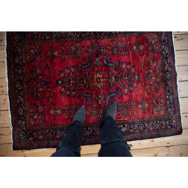 Double floral bouquet outwardly directed atop a covered field of germinating plants. Design is in fine curvilinear...