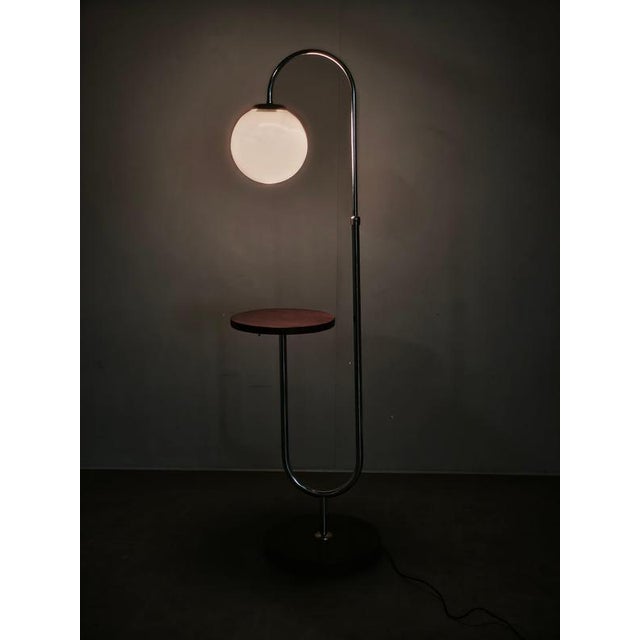 Rare and highly distinctive art deco floor lamp with an integrated side table, produced in czechoslovakia during the...