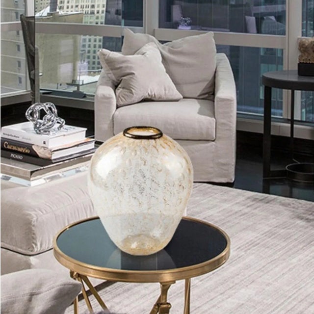 Murano glass vase with a rounded shape, enriched with gold leaf and decorated with circular reliefs. Created in Murano by...