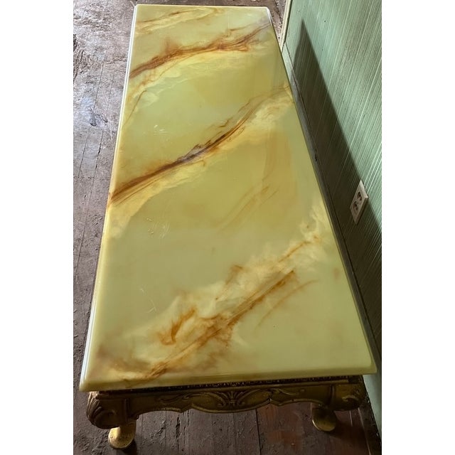 A striking Hollywood Regency cocktail table with a large rectangular onyx slab top with warm amber, honey and rust veining...