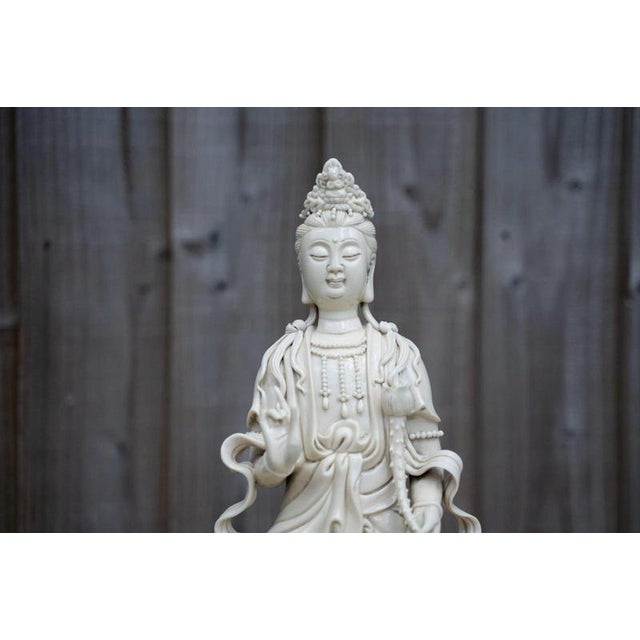 An elegant antique Chinese Blanc de Chine porcelain figure of Guanyin, the Buddhist bodhisattva traditionally associated...