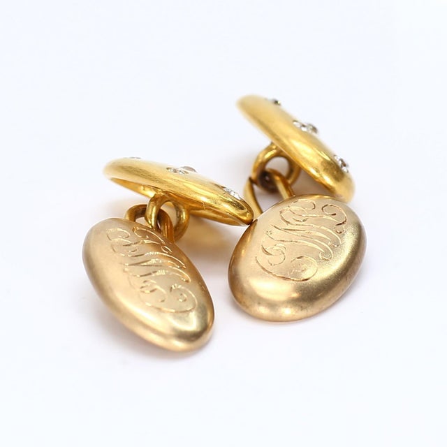 These are 18k yellow gold cufflinks adorned with seven diamonds each. Six 1.5mm stones surrounding a central 2.25mm...