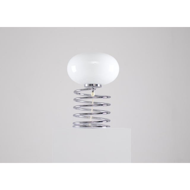 "Ressort" lamp, also known as the "Spirale" or "Spring" lamp, made of chrome-plated steel, featuring its original opaline...