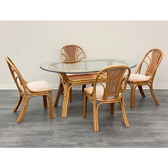 Set of four vintage Scandinavian-style bamboo and rattan chairs with curved frames, sculptural wraparound arms, and woven...