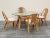 Set of four vintage Scandinavian-style bamboo and rattan chairs with curved frames, sculptural wraparound arms, and woven...