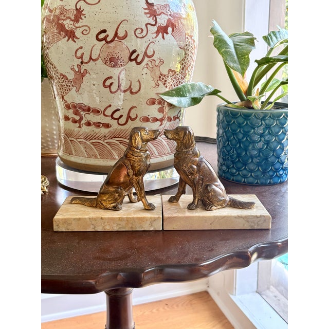 Pair of cast brass sporting dog bookends, modeled as seated setters in mirror-image poses, wearing collars, mounted on...