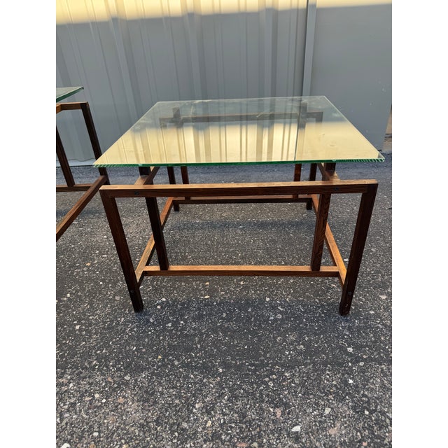 Set of three tables by Komfort of Denmark. Designed by Henning Notgaard. Made with rosewood frames and glass tops. One end...