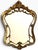 A beautifully ornate vintage wall mirror with an elegant sculptural silhouette and richly detailed gilt-gold frame,...