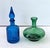 Offered is a striking pair of vintage Italian art glass decanters showcasing the bold color, sculptural forms, and...