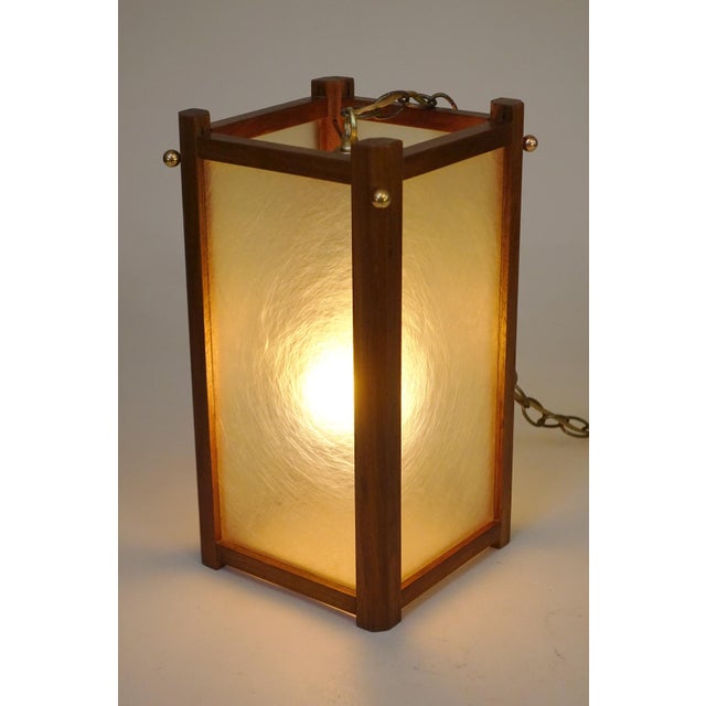 A dramatic yet simple Mid Century Modern Walnut & Fiberglass Lantern shaped form hanging pendant swag style lamp design...