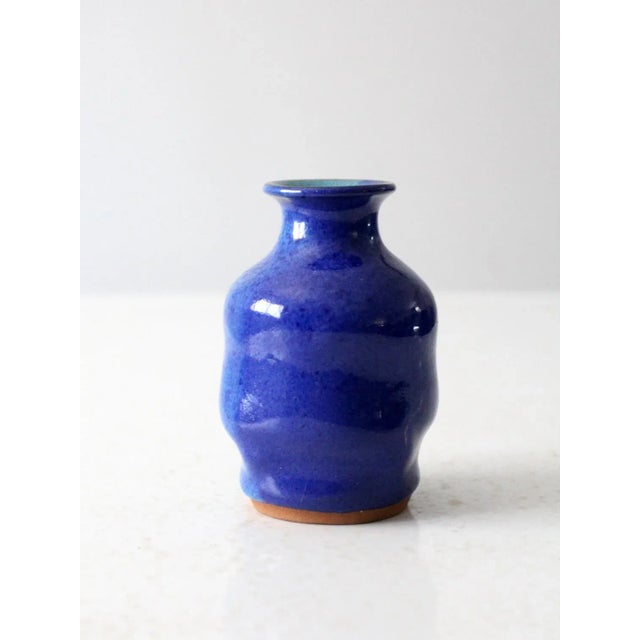 This is a vintage studio pottery vase. Signed by the artist, the handmade vase has a wavy design with vibrant aqua and...