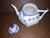 Full lace identified by open work pierced lace framing top rim. The basis of the spout and geometric handle are molded...