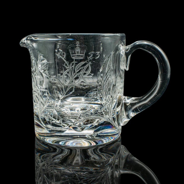 This is a vintage Queen Elizabeth II Coronation jug. An English, glass cordial serving pitcher, dating to the mid 20th...