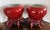 A striking pair of Chinese porcelain jardinieres in a rich oxblood glaze, presented with carved wooden display stands....