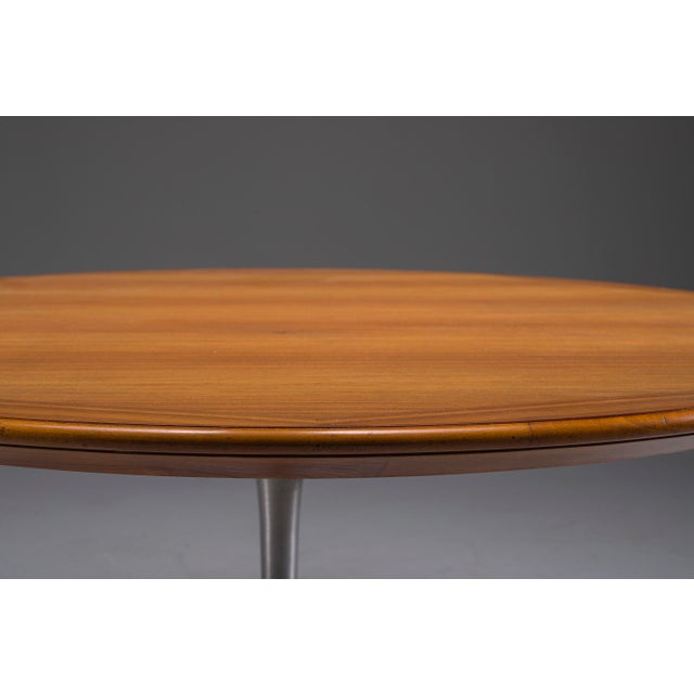 Elegant mid-century round dining table, dating from circa 1960, featuring a beautifully grained walnut top with a refined...