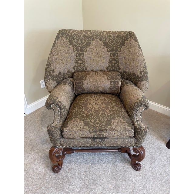 Elegant Tall winged back chair with brown and patterned fabric. Walnut carved cabriole legs. Cushioned seat with matching...