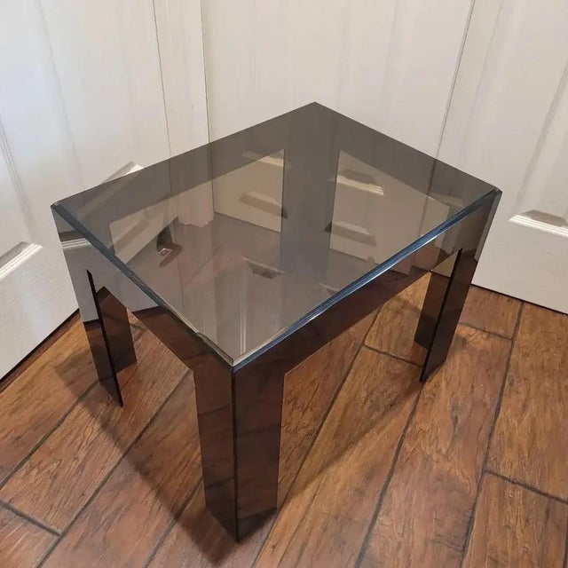 Vintage smoked Lucite (acrylic) end table with a thick beveled top and four broad slab-style legs. The translucent smoked...