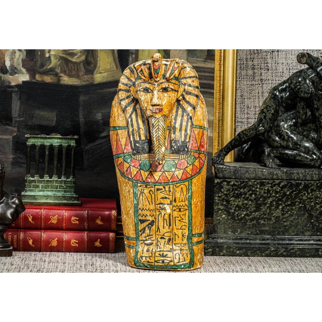 A striking vintage Egyptian painted wood sarcophagus, beautifully hand painted in vivid tones of red, gold, black, and...