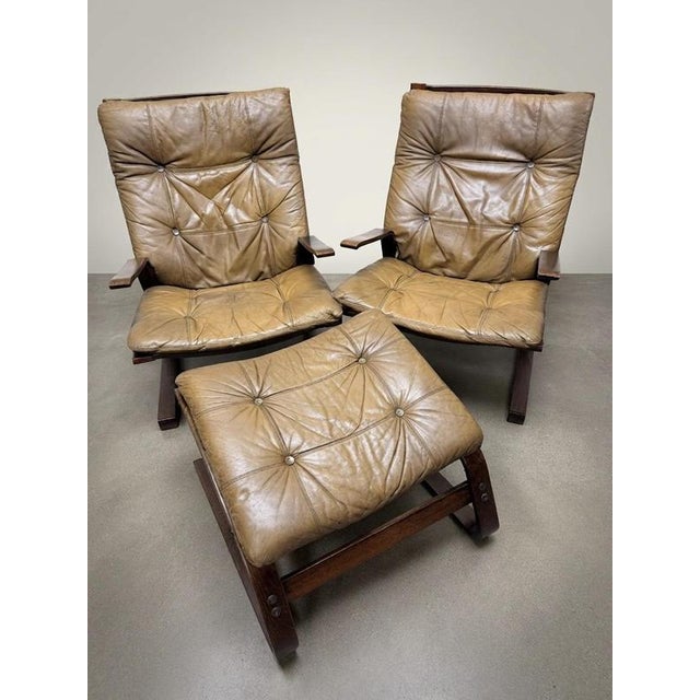 Elevate your space with this iconic pair of vintage Norwegian lounge chairs and matching footstool. Designed in the spirit...