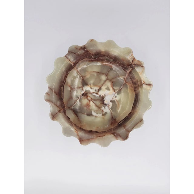 An exceptional decorative bowl, hand-carved in Pakistan from richly veined onyx, stands out for its depth of color and...