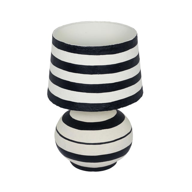 Introducing the Positano Striped Papier Mache Table Lamp, available in striking black or bold blue. Crafted with...