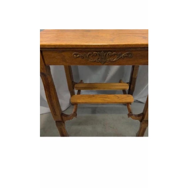 A beautiful 1900‘s library table/desk with fluted cabriole legs and a sled shelf on the bottom. The motif is an acanthus...