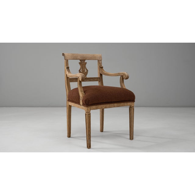 This 19th-century French Neoclassical oak armchair exemplifies refined craftsmanship and timeless elegance. The carved...