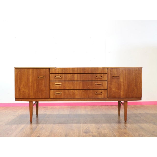 This mid century modern vintage sideboard credenza by Beautility is a stunning piece crafted from teak wood, showcasing...
