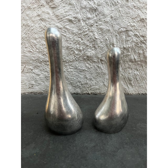 Amorphic shaped silver plated salt & pepper shakers. The bottom of each shaker is stamped “MADE IN HONG KONG E.P.N.S”. The...