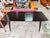 Black lacquered wood dining table with conical legs and chrome details, 1960s. rectangular top in matte black lacquered...