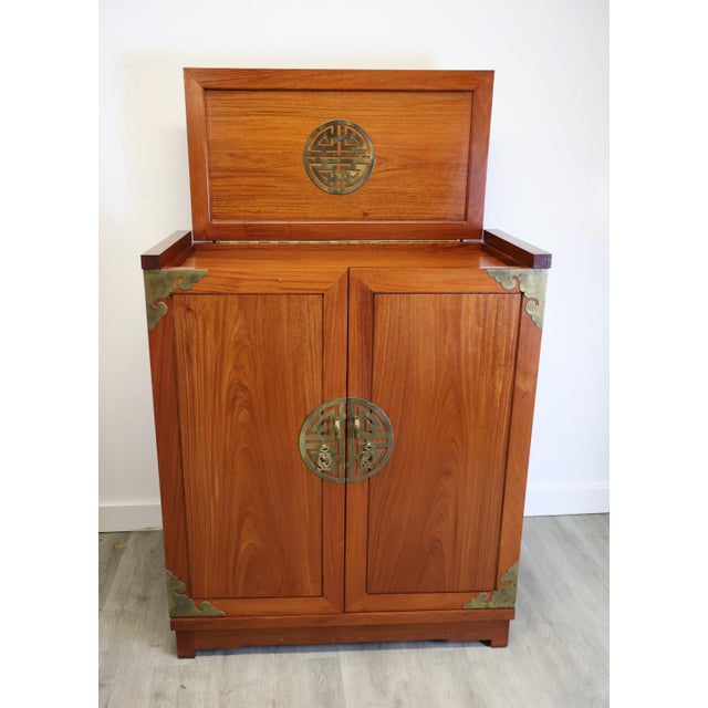 An authentic 1960s George Zee & Co. expanding dry bar cabinet, crafted in richly figured teak with brass corner mounts,...