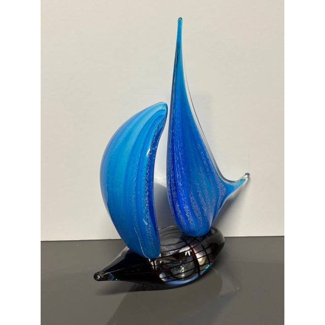 Add a touch of coastal elegance to your décor with this handcrafted blue sailboat art glass sculpture by Dale Tiffany....