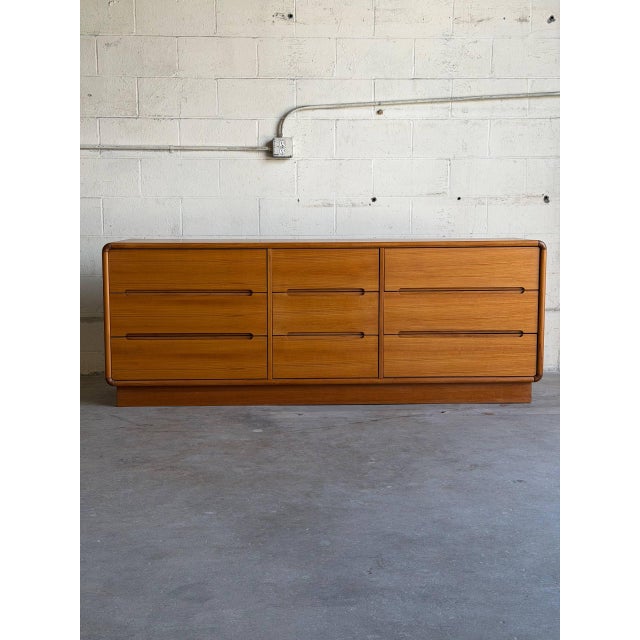 Beautiful Mid Century Modern teak low dresser, featuring a long, clean-lined silhouette with softly rounded edges and...