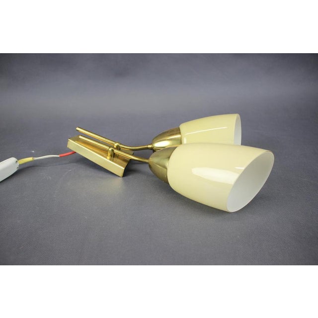 A refined mid-century modern wall light produced by kamenický šenov, czechoslovakia, circa 1960s. The light features...