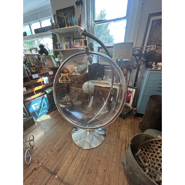 Vintage lucite hanging bubble chair in the style of Eero Aarnio. The hanging chair is a fun clear acrylic sphere suspended...