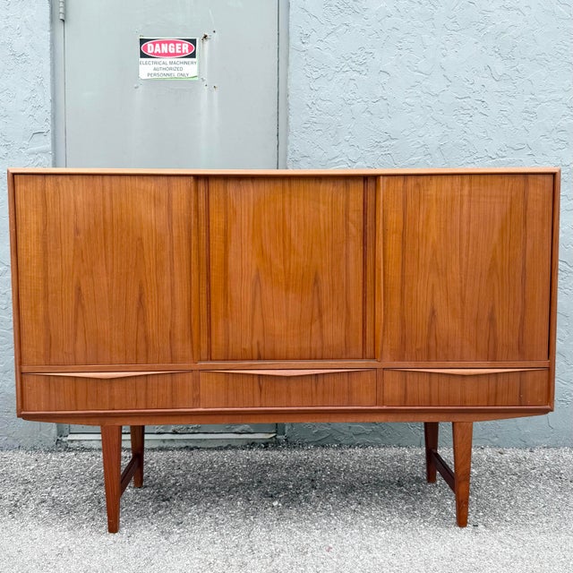 A beautifully crafted Scandinavian Modern teak credenza featuring a warm, richly grained teak veneer and clean...