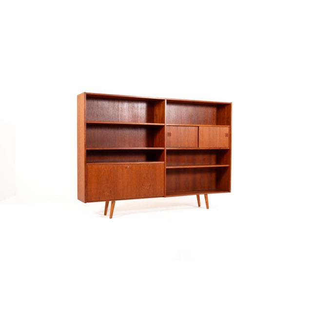 A stunning and highly functional Danish bookcase from the 1960s, crafted in warm teak veneer with a beautiful natural...