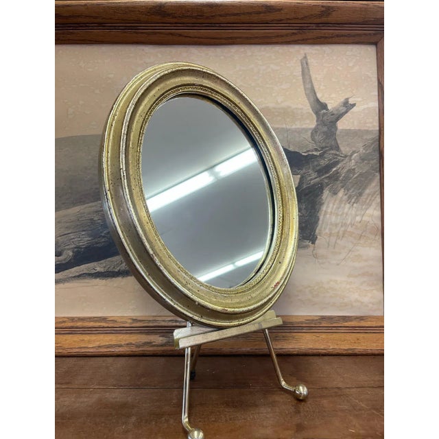 Oval shaped small wall Mirror with gold toned painted wood framing. Stand not included. Vintage Condition Consistent with...