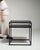 This early 21st century side table from Poland is finished in black, worked in wood. Its form follows honest, well-...