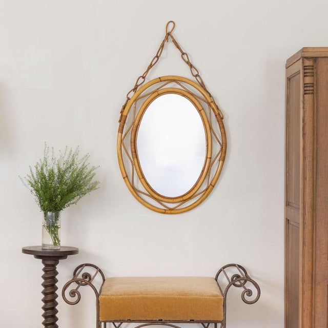 Beautiful rattan mirror in an oval shape from Italy, 1960s. Unique design with wavy zig-zag rattan encompassing the...