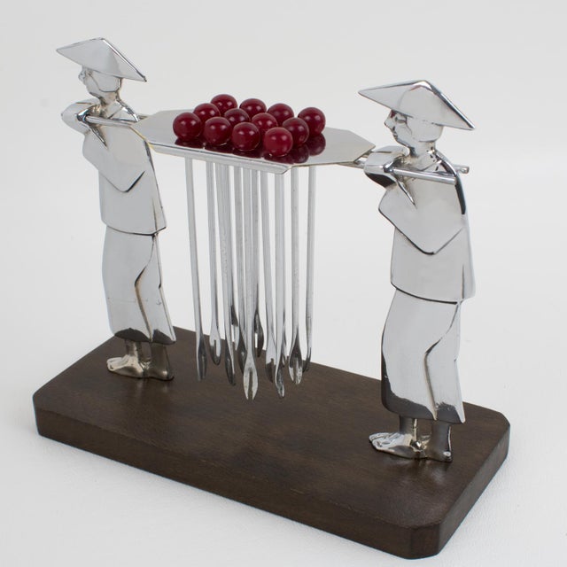 This exquisite barware cocktail pick features two carved chromed metal carriers with a central holder. The rare piece was...