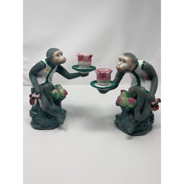 Vintage French Chinoiserie monkey figurine candle holders in pink, green and cream colors, both Monkeys are holding a...