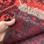Vintage Afghan Bokhara tribal rug featuring three bold stacked Fil-Pa (elephant's foot) octagonal guls in deep oxblood red...